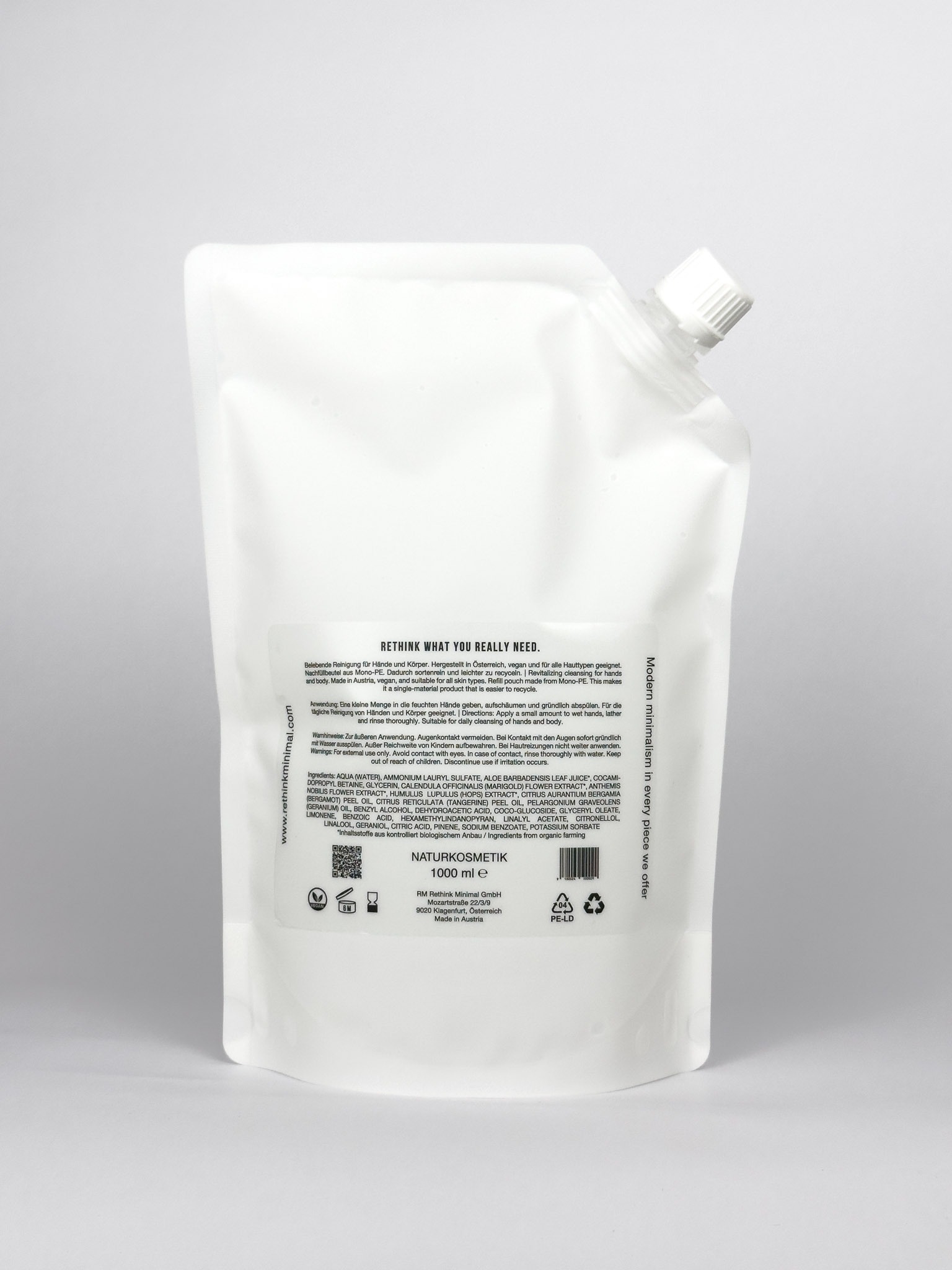 Rückseite eines weißen Refill-Beutels für Rethink Minimal Hand- und Body Wash mit Produktinformationen und Recyclinghinweisen auf hellem Hintergrund.
