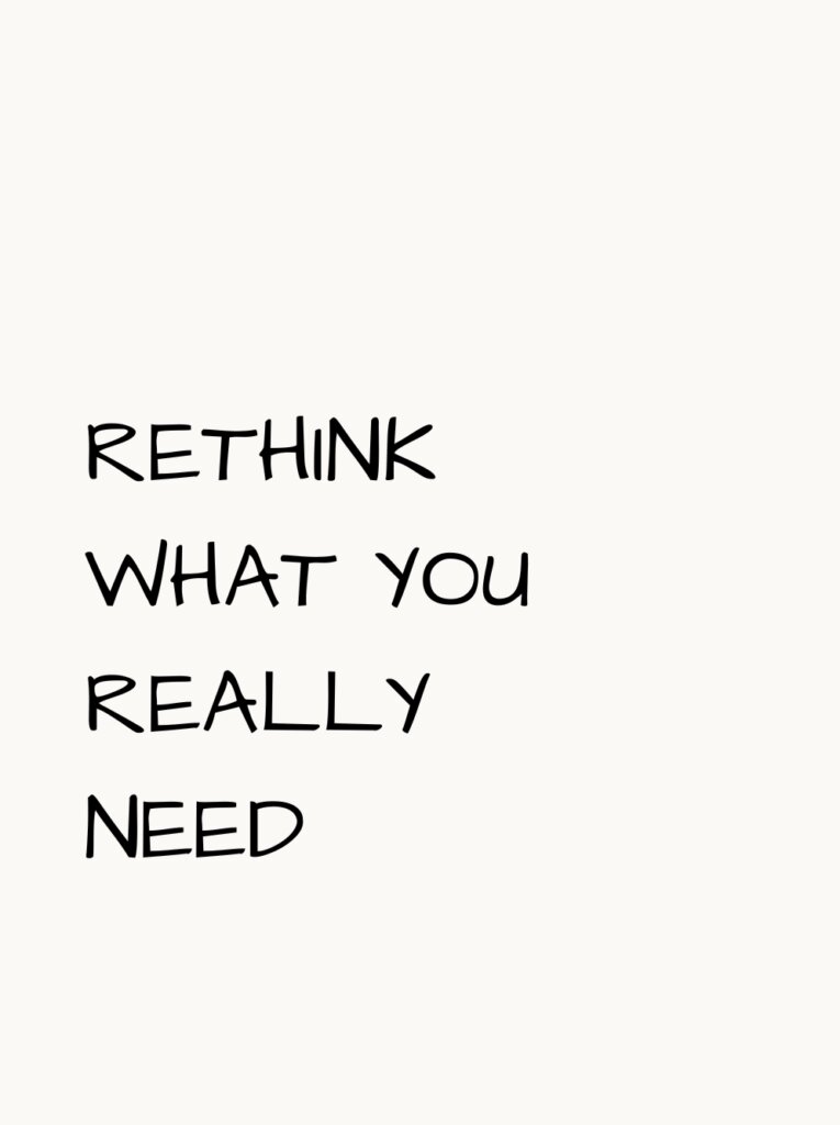 Schwarzer handgeschriebener Text „Rethink what you really need“ auf hellem, ruhigem Hintergrund.