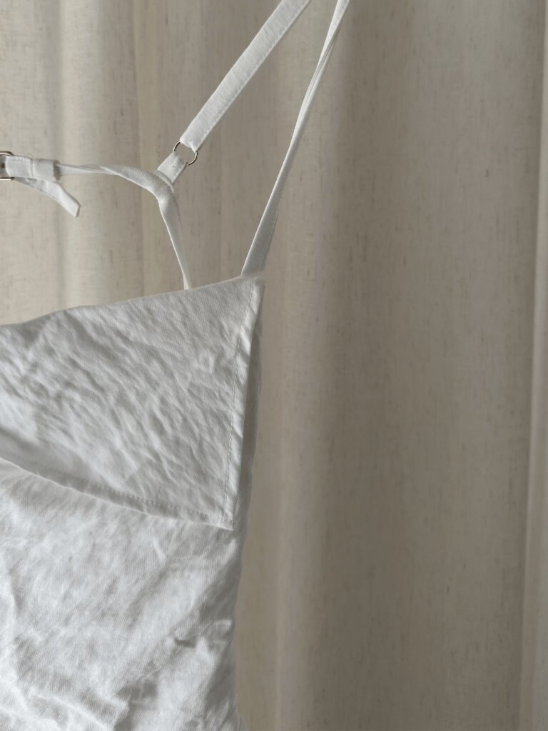 Weißes Jacquemus Designer Kleid "Le Splash" vor weißem Leinenvorhang